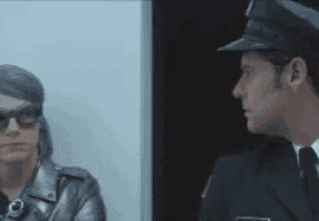 a man in a police uniform is talking to a woman in a leather jacket .