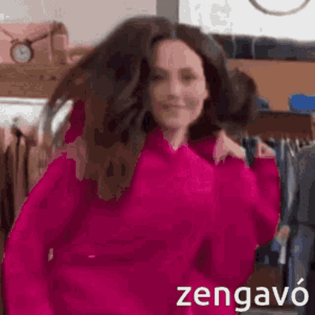 a woman wearing a pink hoodie is standing in a store .