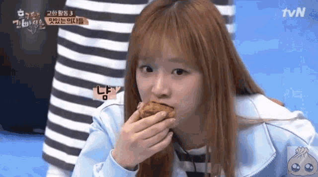 a girl is eating a piece of food and the tvn logo can be seen in the corner