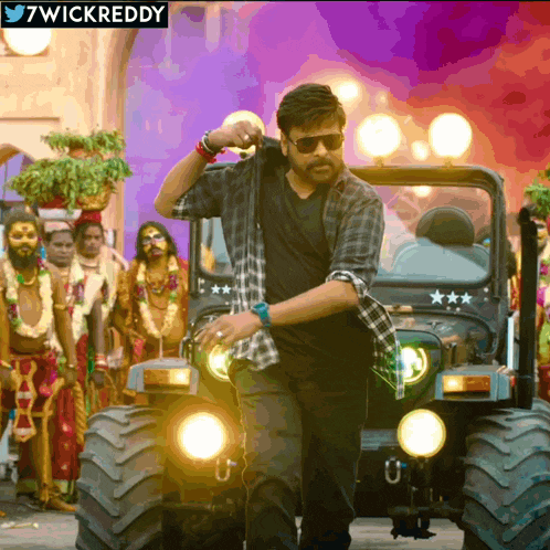 a man in a plaid shirt is standing in front of a jeep with the hashtag 7wickreddy