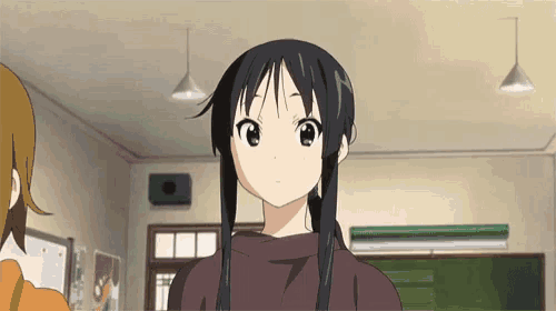 a girl with long black hair is standing in a room with other girls