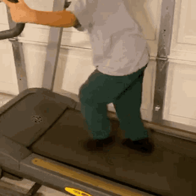 a person is walking on a treadmill with a yellow stripe