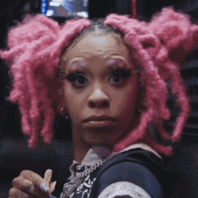 a close up of a woman with pink hair
