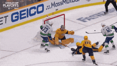 a hockey game is being played in front of a geico banner