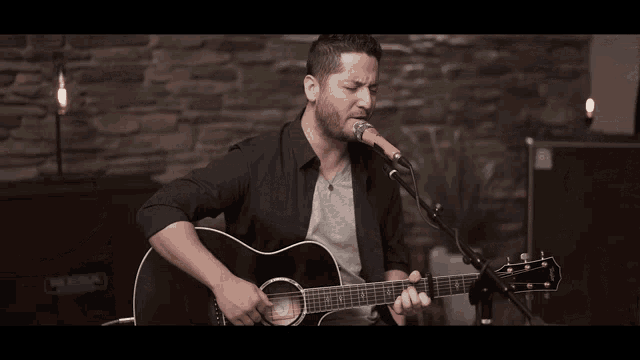 a man is playing an acoustic guitar with the brand name taylor