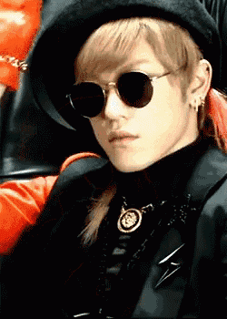 a man wearing a hat and sunglasses looks serious