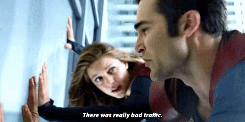 a man and a woman are leaning against a wall . the woman is saying there was really bad traffic .