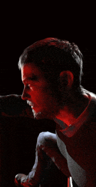 a close up of a man 's face with a red light shining on it