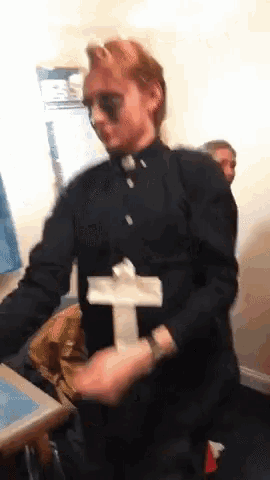 a man in a priest costume is holding a cross