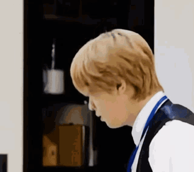 a man in a suit and tie is standing in front of a door in a room .