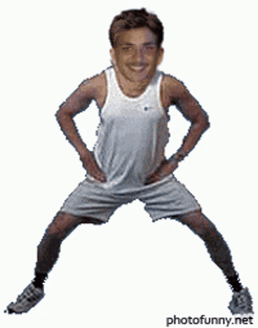 a man in shorts and a white tank top is standing with his legs crossed