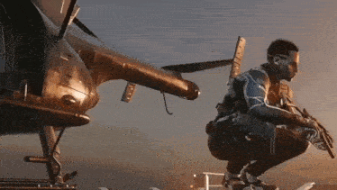 a man kneeling down with a gun in front of a plane