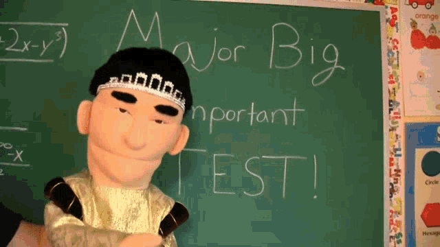 a puppet is standing in front of a chalkboard that says major big important test