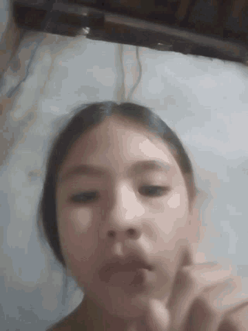 a young girl is laying on a bed with her eyes closed and her tongue out .