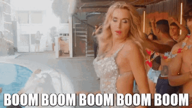 a woman in a white dress is dancing in front of a pool with the words boom boom boom boom boom boom written below her