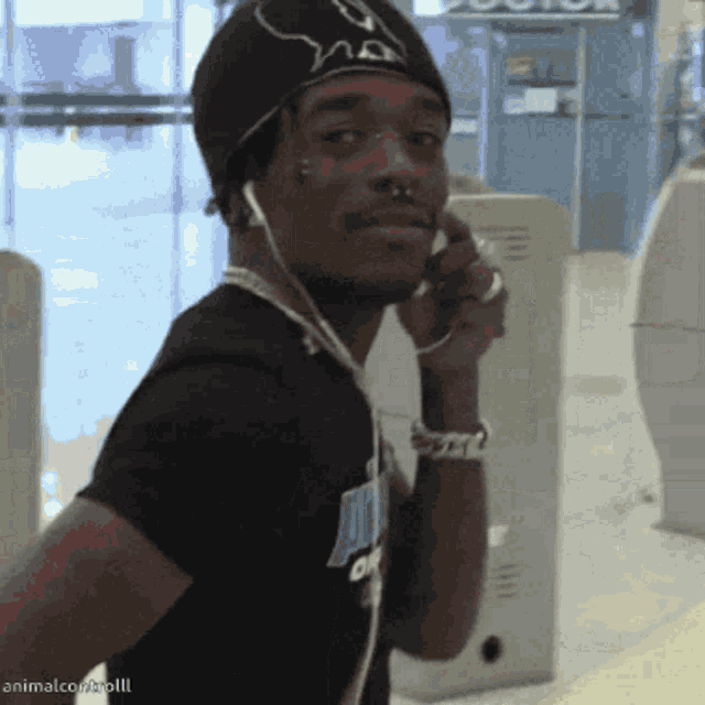 a man wearing a black shirt that says ok on it is talking on a cell phone