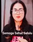 a woman wearing glasses is holding a microphone in her hand .