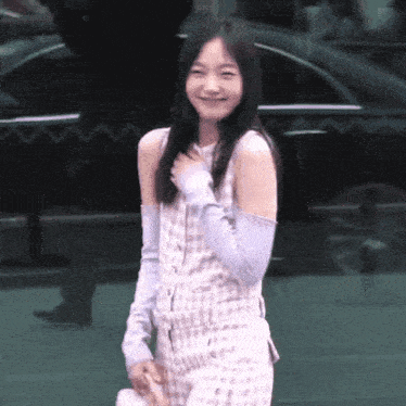 a woman wearing a plaid top and purple sleeves smiles for the camera