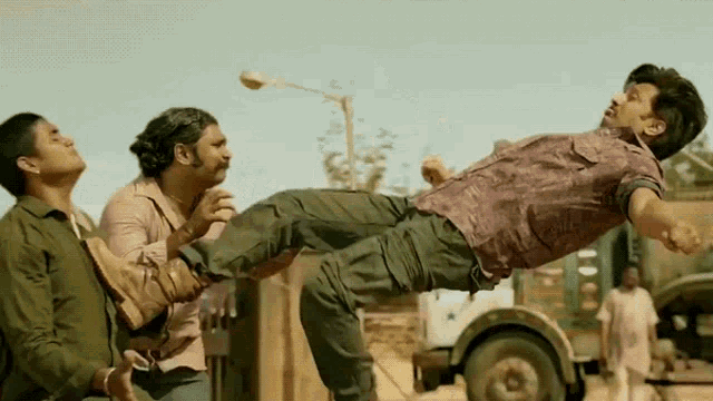 a man is being lifted up in the air by two other men