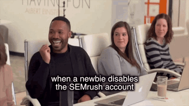 a group of people are sitting around a table with a sign that says " when a newbie disables the semrush account "