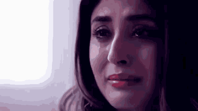 a close up of a woman 's face with a tear running down her cheek .