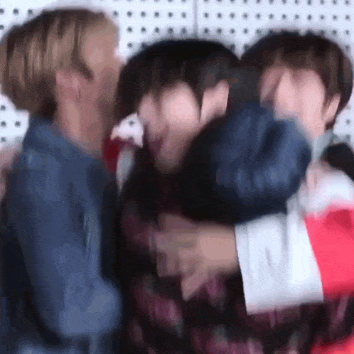 a group of young men are hugging each other .