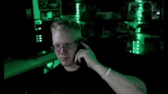 a man wearing glasses is talking on a cell phone