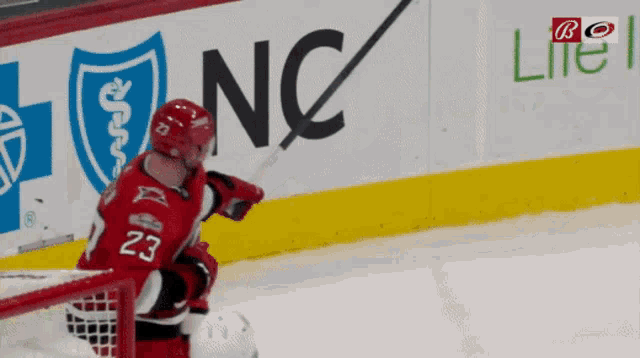 a hockey player with the number 23 on his jersey stands on the ice
