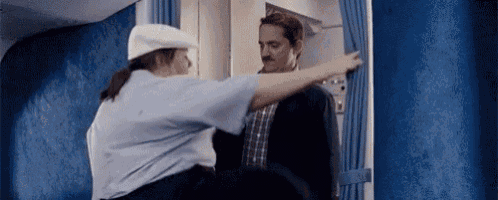 a man in a suit is being searched by a woman on an airplane .