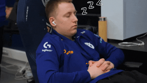 a man in a blue logitech shirt is sleeping on a chair
