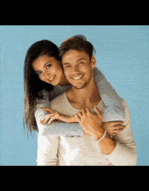 a man is carrying a woman on his back and both are smiling
