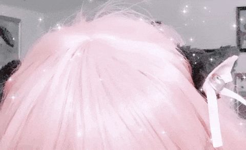 a close up of a person 's head with pink hair and ears .