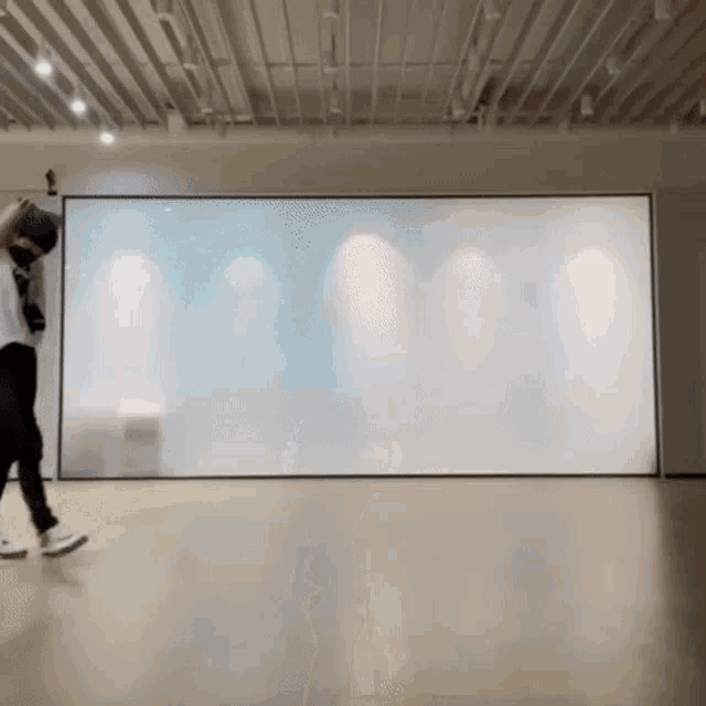a person is standing in front of a large white board