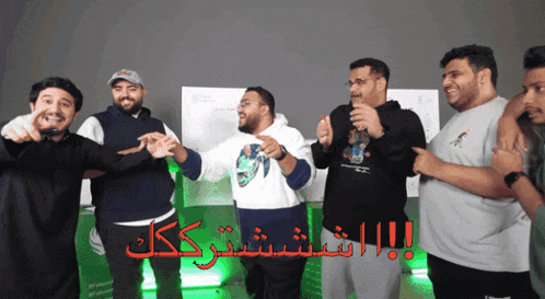 a group of men are standing next to each other with arabic writing on the bottom right