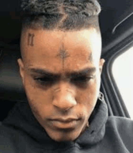 a close up of a man with a tattoo on his forehead .