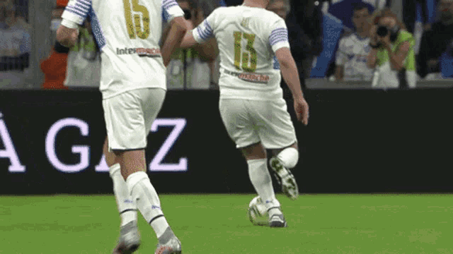 two soccer players on a field with one wearing a number 15 jersey