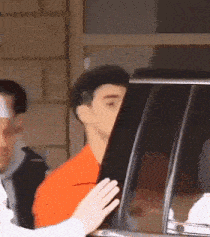 a man with a bandage on his head is getting out of a car