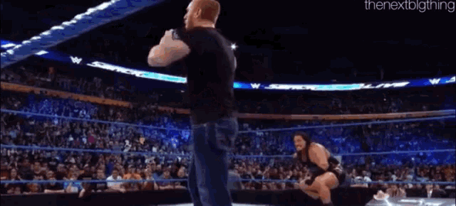 a man is being thrown in the air by another man in a wrestling ring .