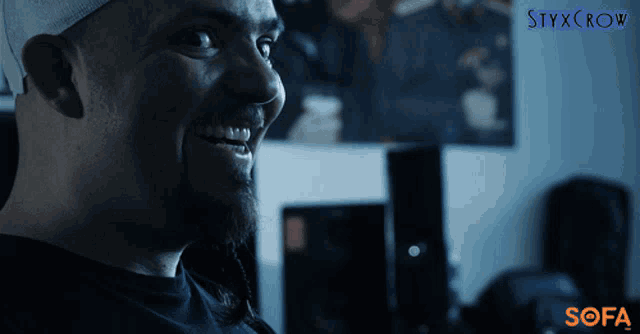 a man is smiling in front of a poster that says styxcrow on it