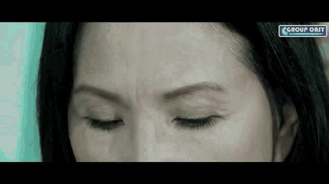 a close up of a woman 's face with a sign that says group on it