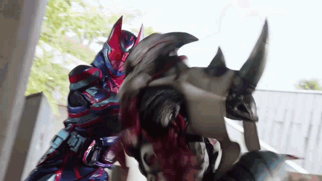 a man in a robot costume is fighting another man in a robot costume with horns .