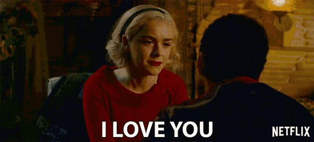 a man and a woman are looking at each other and the woman says i love you on the screen