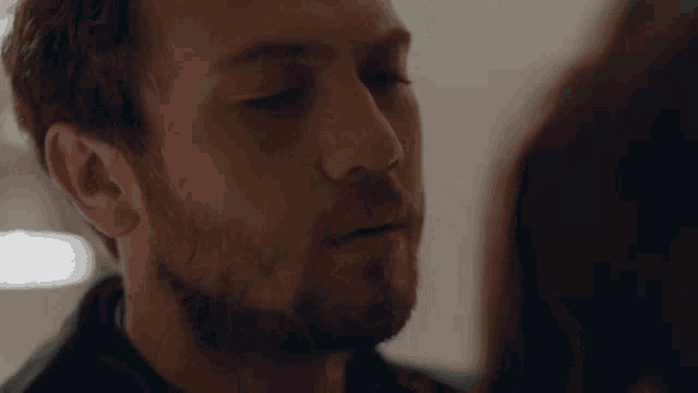 a man with his eyes closed looks at a woman