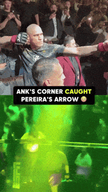 a man in a ufc shirt stands in a crowd
