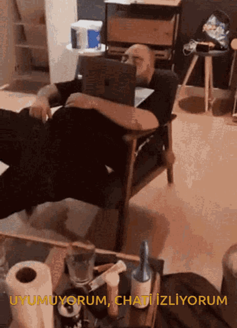 a man laying on a chair with a laptop and the words uyumuyor chati izliyorum