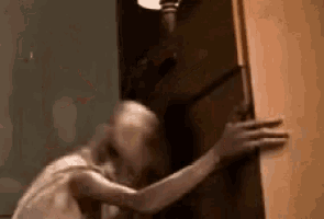 a person is standing in a doorway holding a door open .