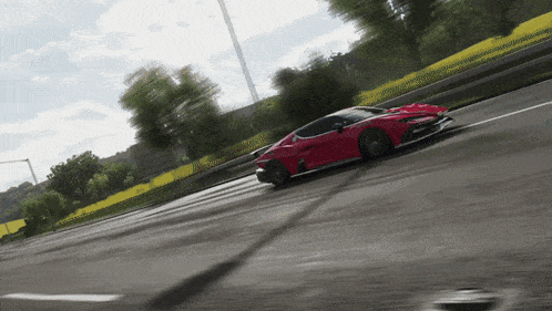 a red car is driving down a road in a video game