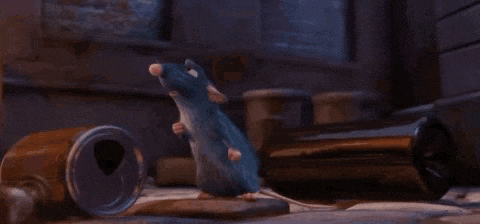 a cartoon mouse is crawling on the ground in front of a trash can .