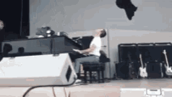 a man is sitting at a piano on a stage