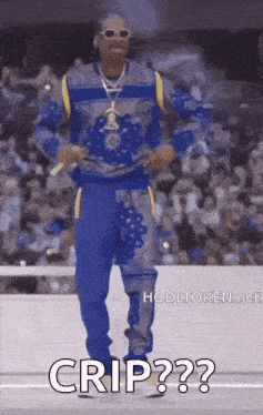 snoop dogg is wearing a blue sweater and blue pants while standing on a stage .